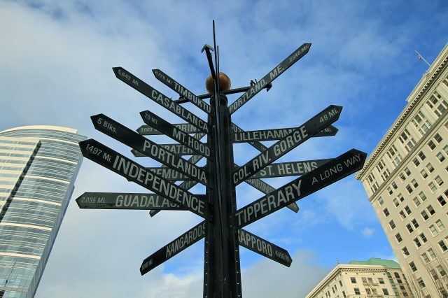 a city street sign with many street signs pointing in separate directions