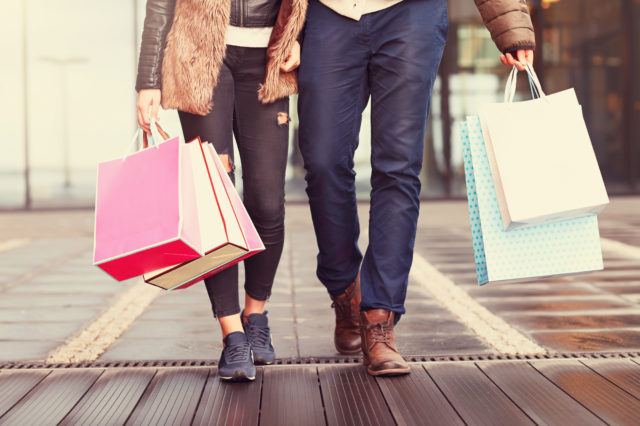 a couple shopping in the city with shopping bags with fall wardrobe
